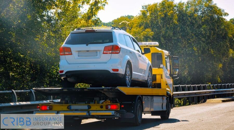 Tow truck towing a broken-down car on the roadside